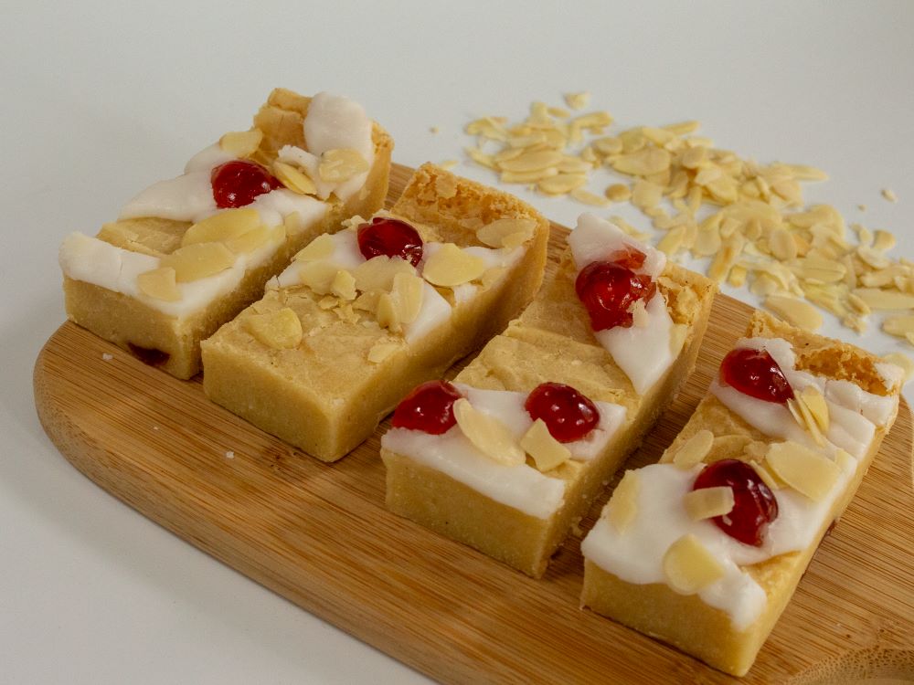 Bakewell blondies freshly made, with cherries almonds and icing. An absolute classic.